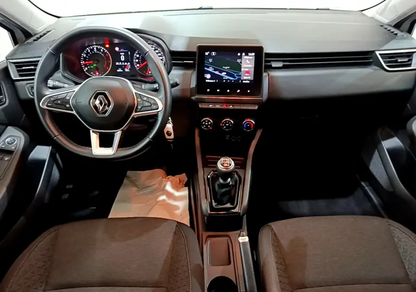 Vue intérieure avant de la Renault Clio Business TCe 90 2021, tableau de bord noir avec écran tactile central et volant multifonctions.