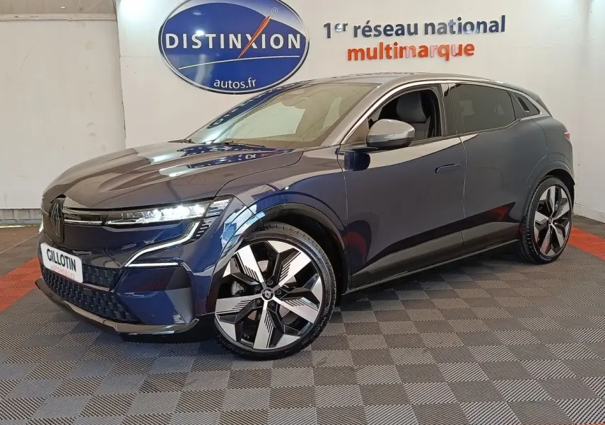 Vue 3/4 avant droite d'une Renault Mégane Techno EV60 bleu électrique avec jantes distinctives et phares LED allumés.