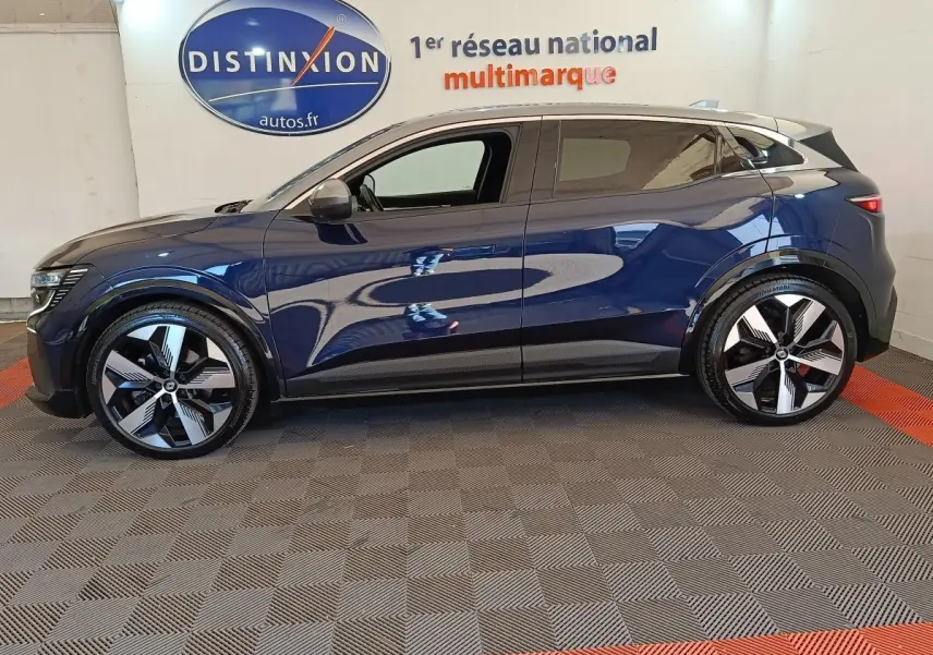 Profil côté gauche de la Renault Mégane Techno EV60 bleu électrique 2023 avec jantes modernes et toit clair.