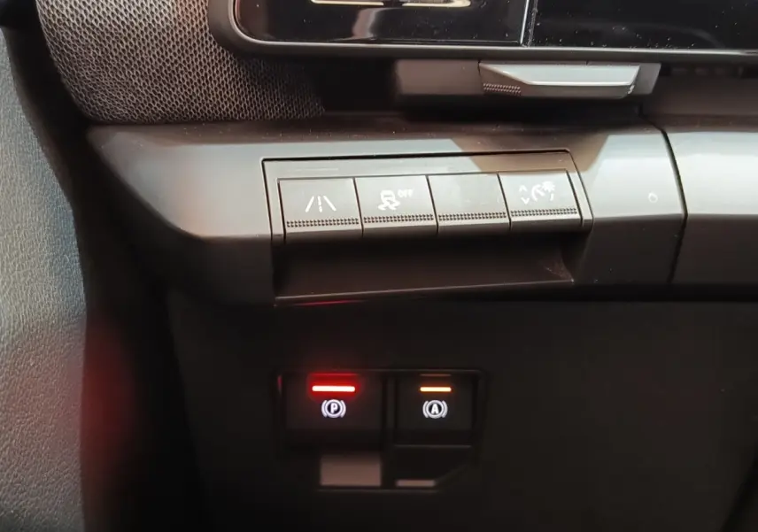 Gros plan sur les commandes de sécurité et assistance au freinage de la Renault Mégane Techno EV60 bleu.
