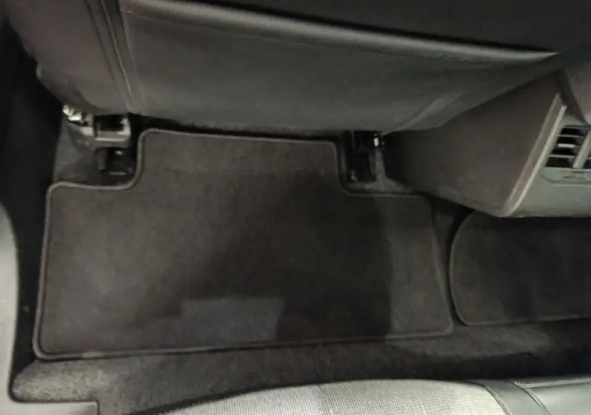 Vue plongeante sur le tapis de sol noir côté passager avant de la Renault Megane Techno EV60 2023.