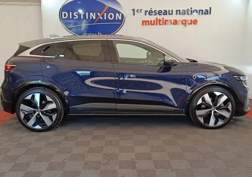 Profil droit d'une Renault Mégane Techno EV60 bleu électrique, avec jantes modernes et toit noir contrasté.
