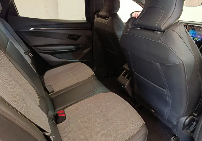 Vue intérieure arrière côté gauche de la Renault Mégane Techno EV60 220ch avec sièges tissu et cuir gris foncé.
