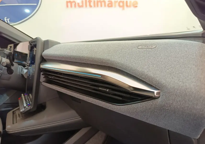 Détail intérieur du tableau de bord gris clair avec aérateurs et écran tactile de la Renault Mégane Techno EV60 2023.