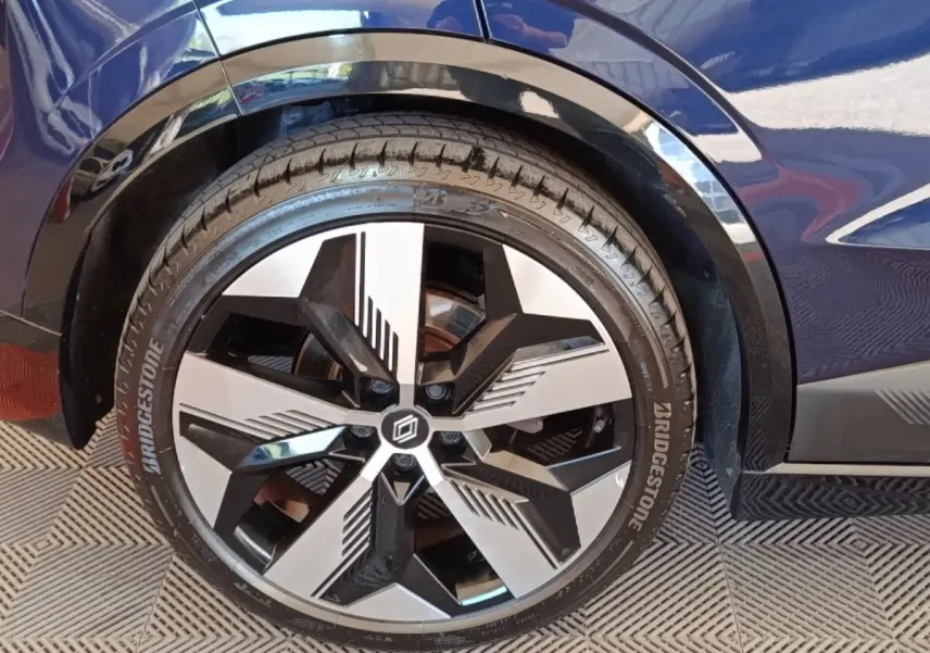 Gros plan sur la roue avant droite de la Renault Mégane Techno EV60 bleu, avec jante diamantée au design moderne.