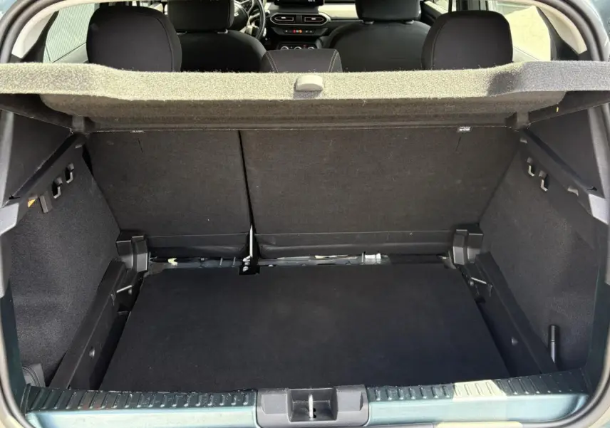 Coffre ouvert vu de l'arrière d'une Dacia Sandero Stepway Vert Cèdre, avec banquette arrière et cache-bagages visibles.