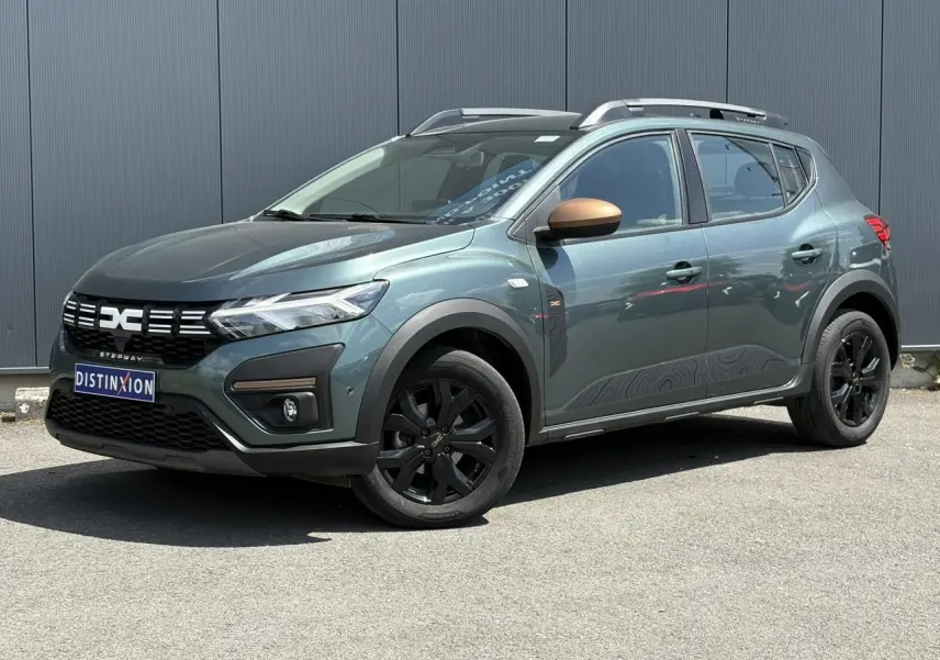 Dacia Sandero Stepway 2025 Vert Cèdre en 3/4 avant droit avec jantes noires et coques de rétroviseur cuivrées.
