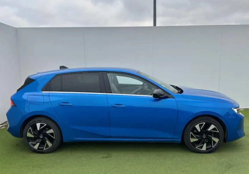Opel Astra VI bleu clair vue de profil côté gauche avec jantes alliage noires et vitres surteintées.