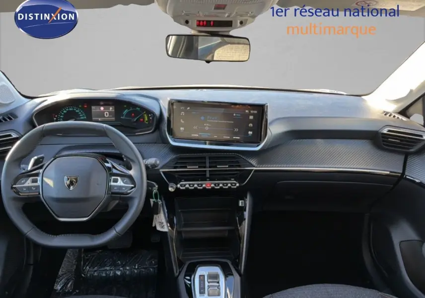 Vue intérieure avant du Peugeot 208 gris avec tableau de bord numérique et écran tactile central moderne.