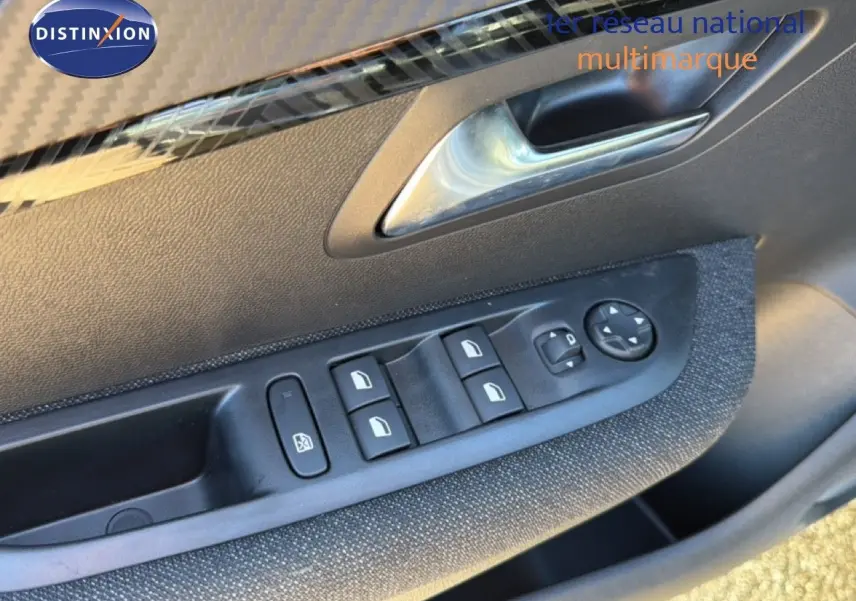 Commandes des vitres électriques et réglage des rétroviseurs sur la porte côté gauche d'une Peugeot 208 gris Artense 2025.