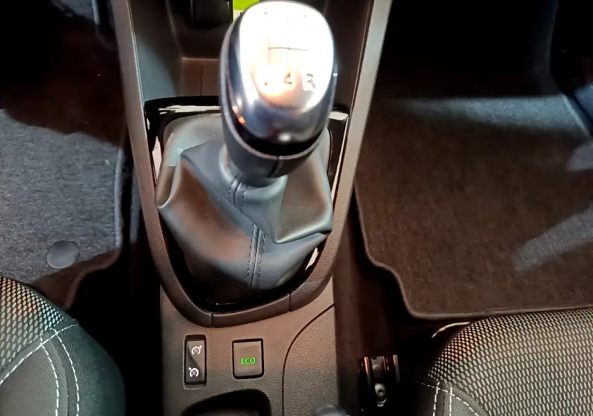 Vue rapprochée du levier de vitesses manuel et des boutons Eco dans l'habitacle noir de la Renault Clio Business gris clair.