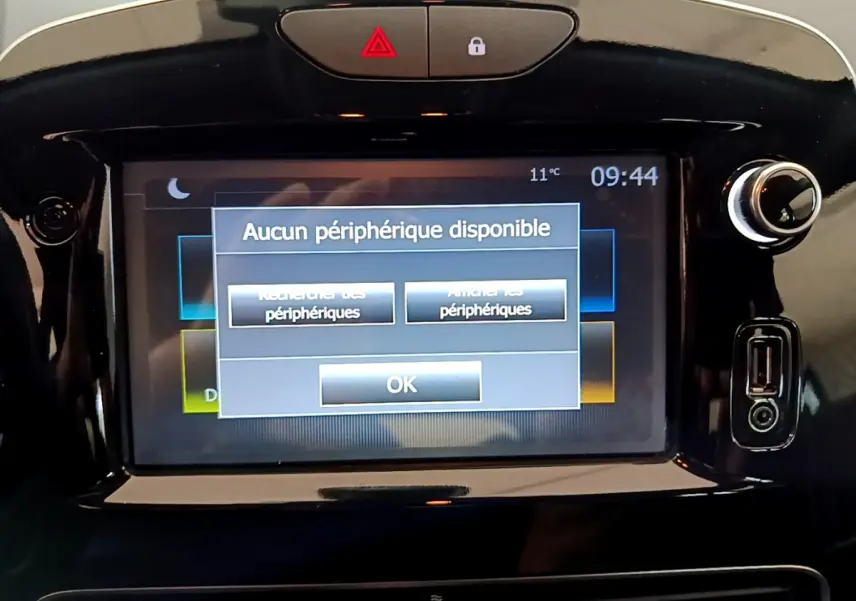 Écran tactile central affichant un message d'absence de périphérique dans une Renault Clio Business gris clair, vue frontale rapprochée.