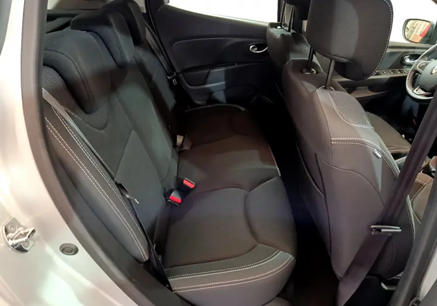 Vue intérieure côté gauche arrière de la Renault Clio Business gris clair, sièges noirs avec surpiqûres blanches visibles.