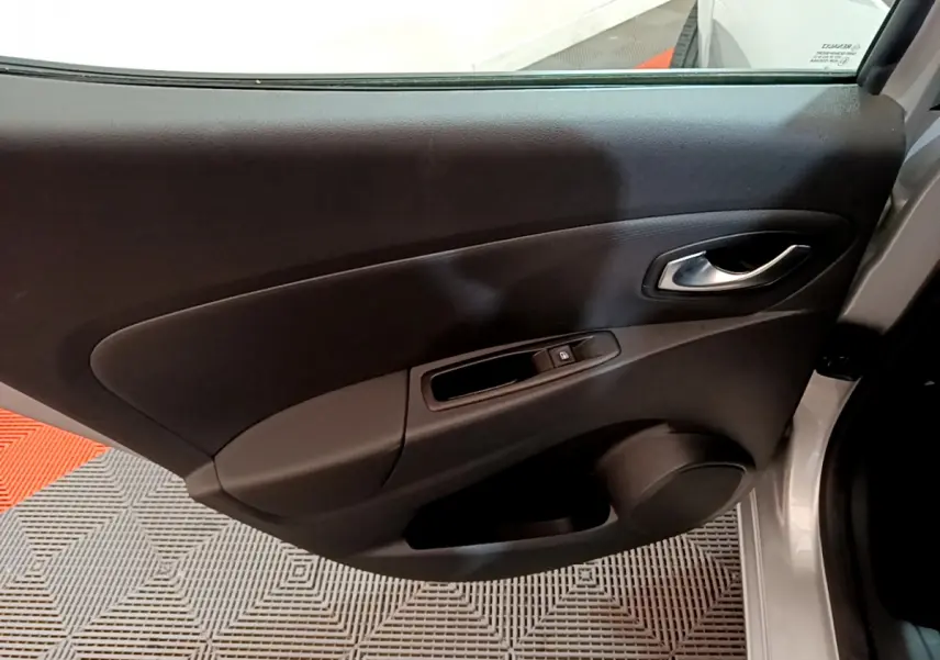 Vue intérieure de la porte avant droite grise de la Renault Clio Business TCe 90 avec poignée et commande de vitre.