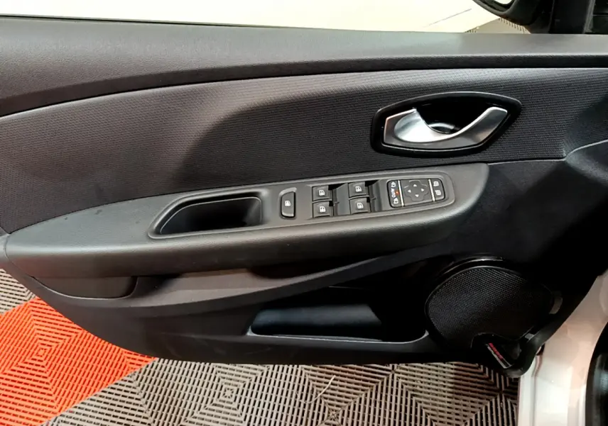 Vue rapprochée de la porte côté conducteur de la Renault Clio Business TCe 90 gris clair avec commandes électriques et haut-parleur intégré.