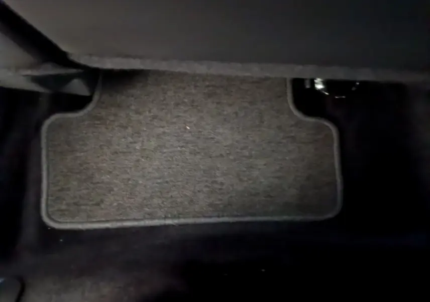 Tapis de sol gris foncé vu de près sous le tableau de bord côté conducteur d'une Renault Clio Business TCe 90 2019.