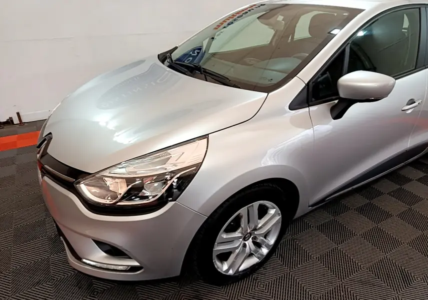 Renault Clio Business TCe 90 gris clair vue 3/4 avant droit, avec phares LED et jantes alliage visibles.