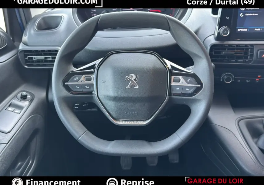 Vue rapprochée du volant multifonction noir du Peugeot Rifter 2024 avec tableau de bord et commandes visibles.