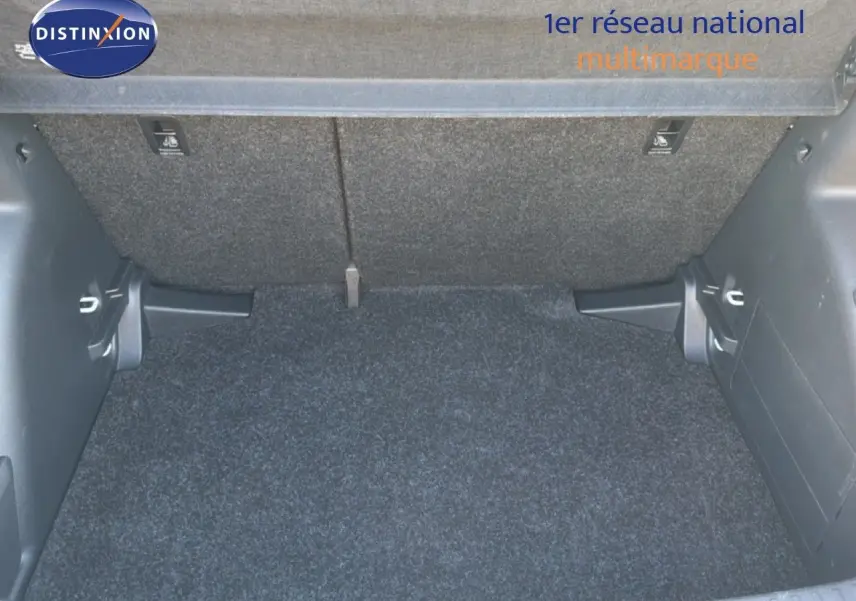 Coffre ouvert d’une Skoda Fabia blanc glacier, vue intérieure montrant le tapis et les parois du coffre.