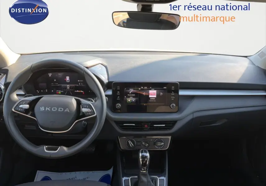 Vue frontale de l’habitacle de la Skoda Fabia blanc glacier 2025, avec tableau de bord numérique et écran tactile central.