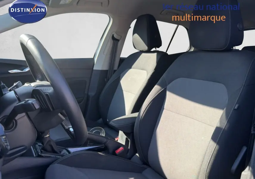 Vue intérieure côté gauche montrant les sièges tissu noir et gris et le volant cuir multifonction d'une Skoda Fabia blanc glacier 2025.