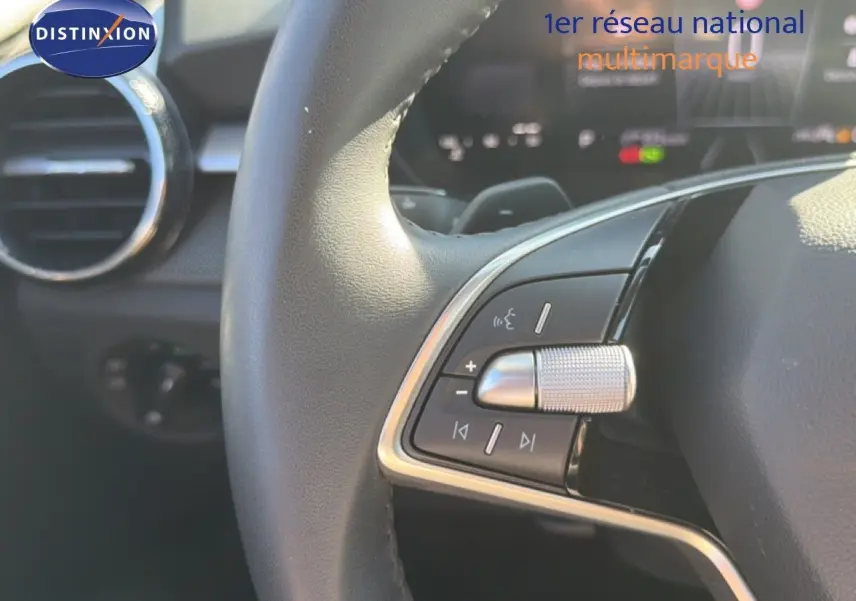Gros plan sur les commandes multifonctions du volant noir de la Skoda Fabia 2025, avec aérateur circulaire en arrière-plan.