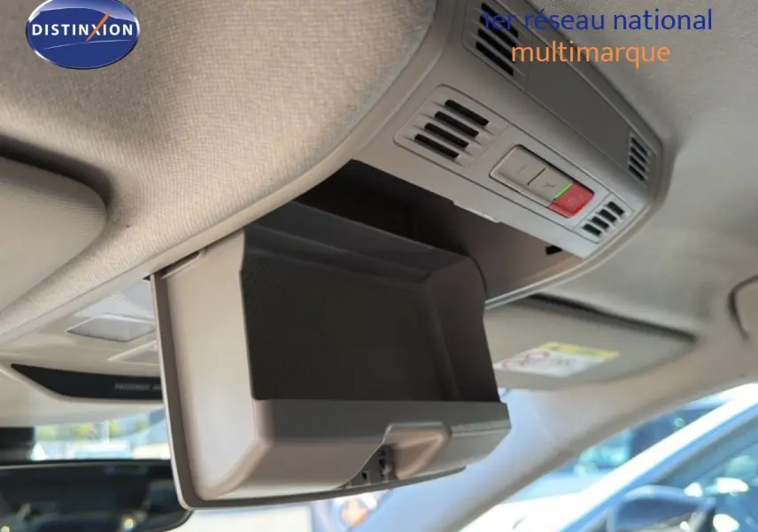 Détail intérieur montrant le rangement lunettes ouvert au plafond d'une Skoda Fabia blanc glacier, avec commandes intégrées.
