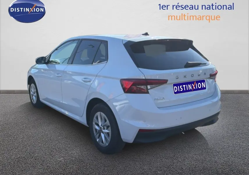 Vue 3/4 arrière droite d'une Skoda Fabia blanche glacier 2025 avec feux arrière LED et jantes alliage 15 pouces.