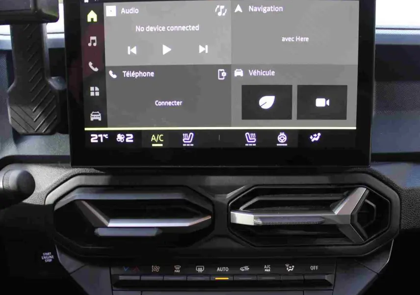 Écran tactile central avec interface CarPlay et aérateurs hexagonaux noirs du Dacia Duster noir, vue intérieure frontale.