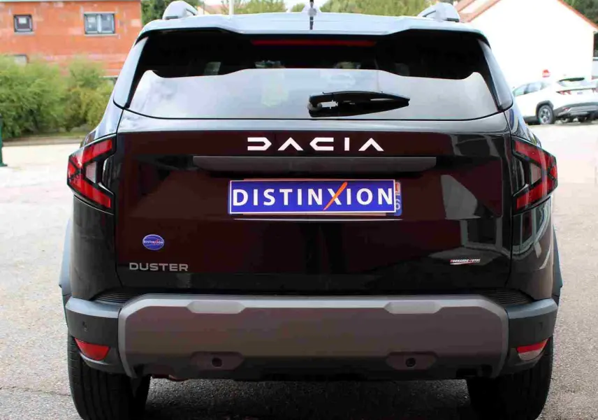 Vue arrière d'un Dacia Duster noir avec logo DACIA lumineux et plaque d'immatriculation Distinxion.