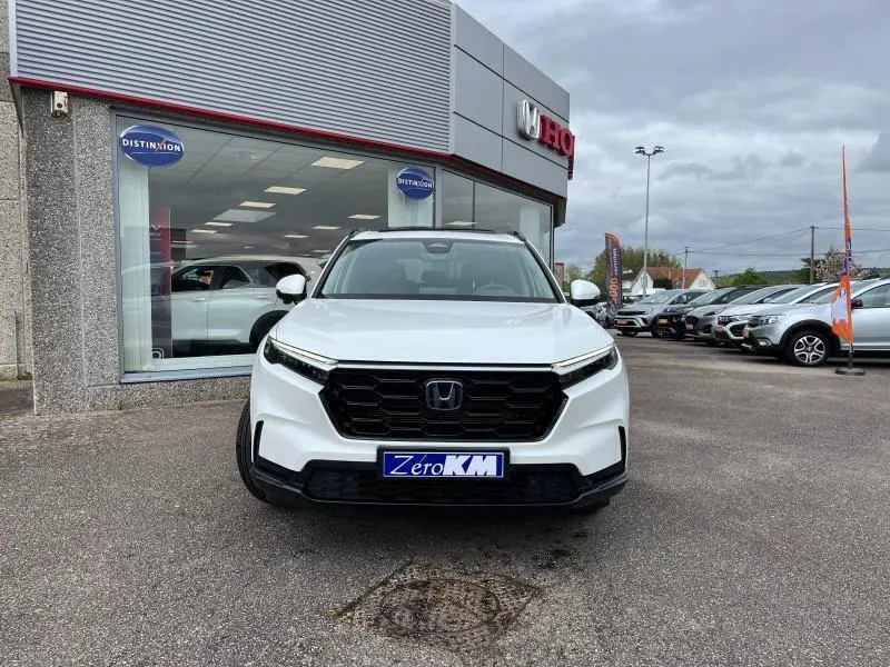 Vue de face d'un Honda CR-V 2024 blanc platine nacré, avec calandre noire et plaque "Zero KM" visible.