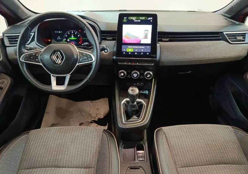 Vue frontale de l'habitacle de la Renault Clio Techno TCe 90 2024, volant cuir, écran tactile vertical et boîte manuelle.