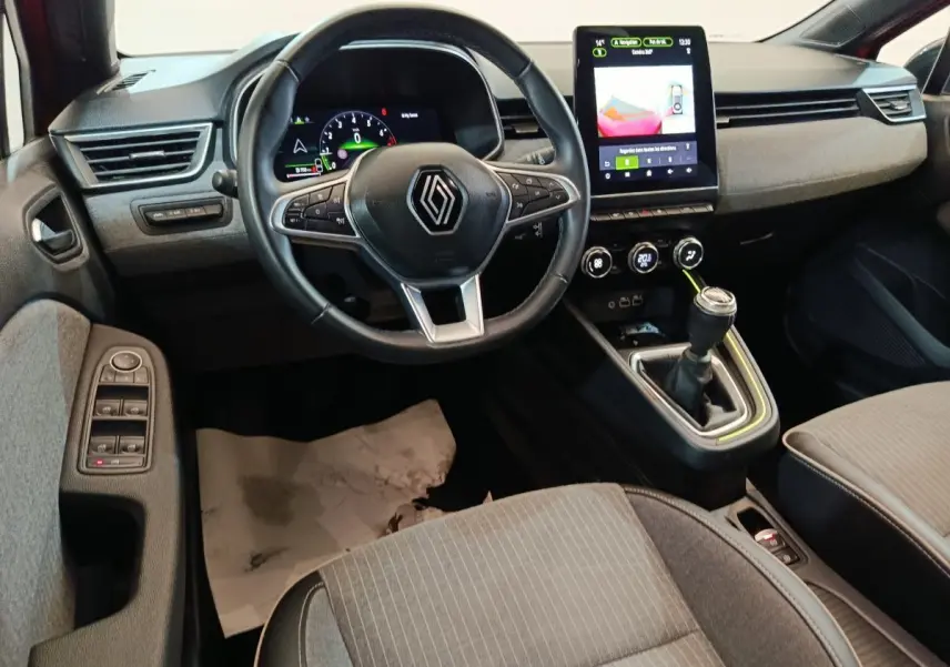 Intérieur de la Renault Clio Techno TCe 90 vue côté conducteur, volant cuir et écran tactile central allumé.