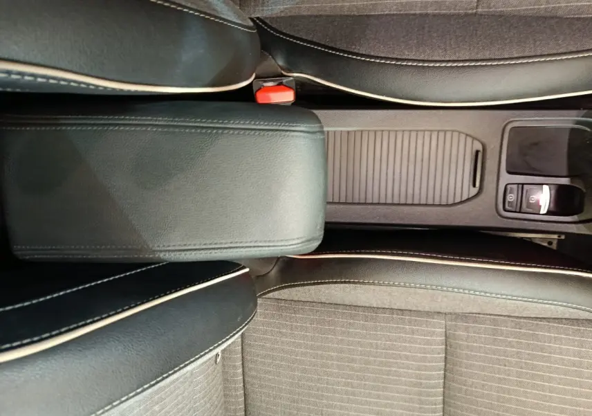 Vue plongeante sur la console centrale noire et les sièges gris foncé avec surpiqûres blanches de la Renault Clio 2024.