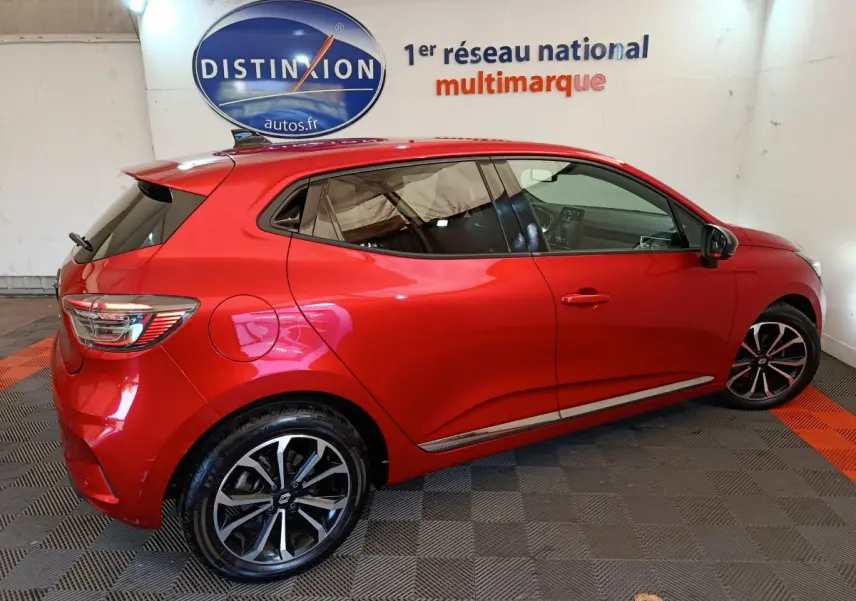 Renault Clio Techno TCe 90 rouge vue de profil côté gauche, avec jantes alliage et vitres teintées.