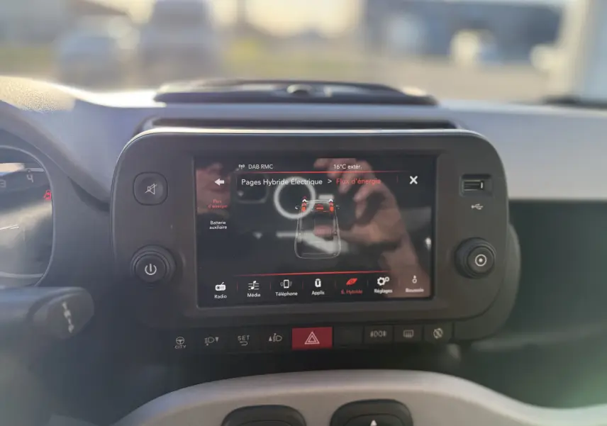 Vue rapprochée de l'écran tactile central de la Fiat Panda City Cross gris minuit, affichant le flux d'énergie hybride.