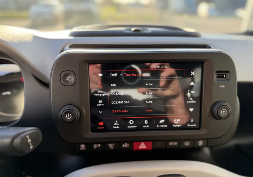 Écran tactile central du tableau de bord de la Fiat Panda City Cross 2023 affichant la liste des radios DAB.