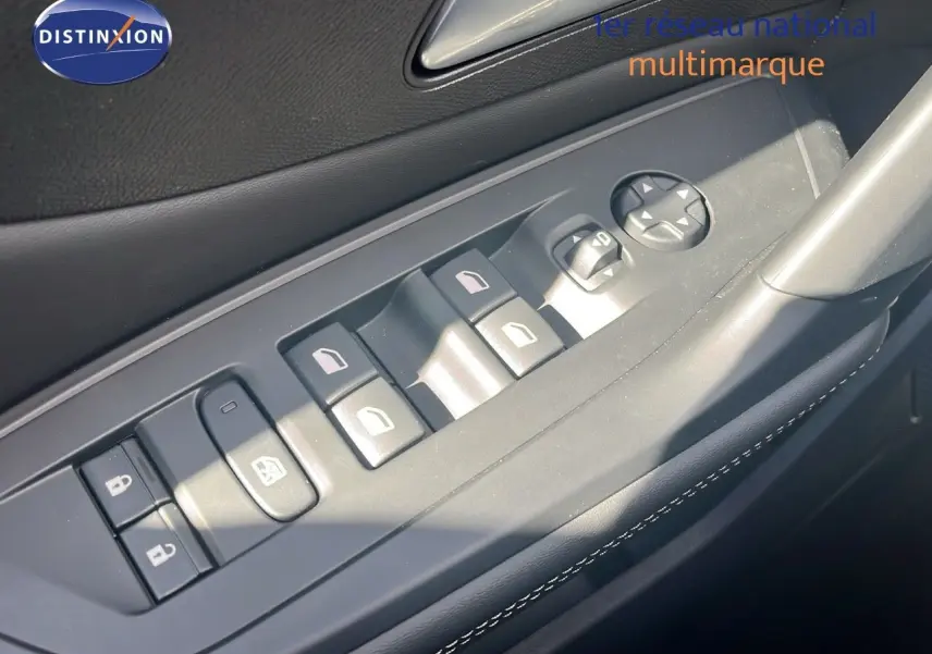 Gros plan sur les commandes des vitres et rétroviseurs côté conducteur d'une Peugeot 308 vert olivine métal.