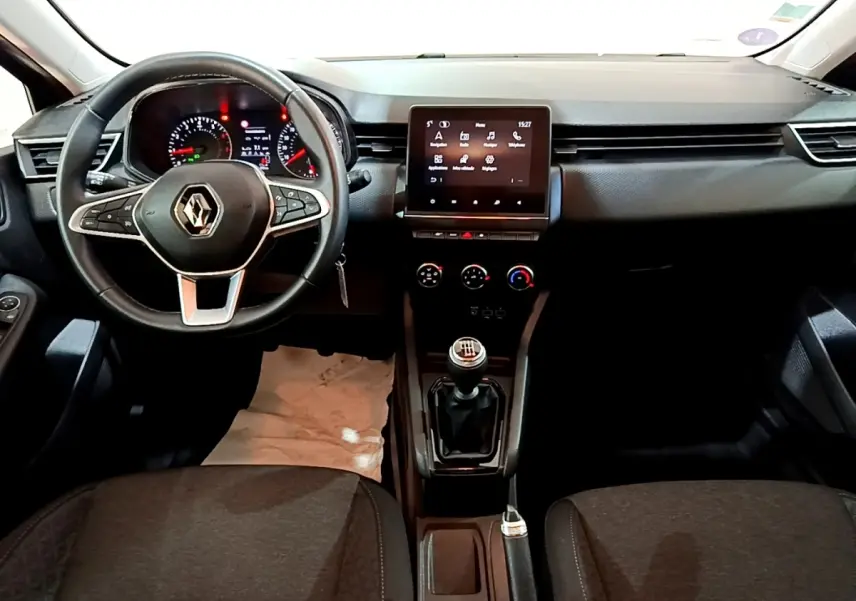 Vue intérieure frontale du tableau de bord noir de la Renault Clio Business TCe 90 avec volant cuir et écran tactile central.