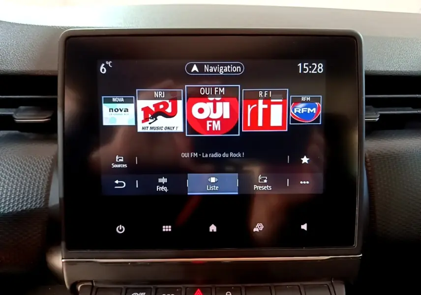 Écran tactile central de la Renault Clio Business TCe 90 2022 affichant les stations radio avec commandes en dessous.