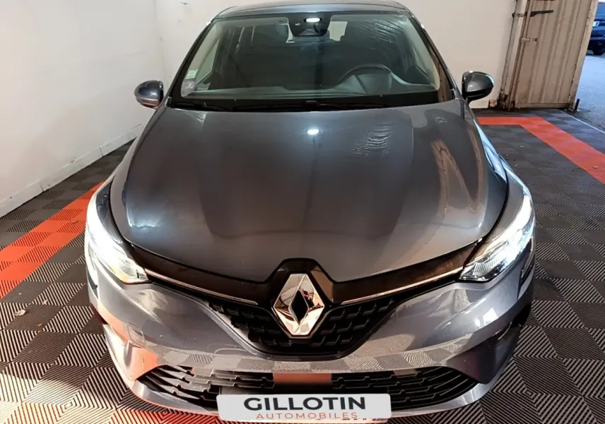 Vue de face d'une Renault Clio Business TCe 90 gris foncé avec feux LED allumés dans un garage.