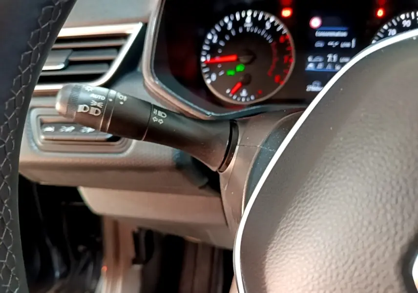 Gros plan sur le commodo gauche et le tableau de bord éclairé d'une Renault Clio Business TCe 90 gris foncé, 2022.