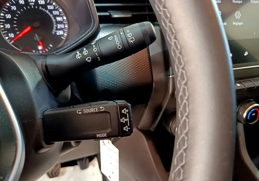 Gros plan sur la commande au volant et le tableau de bord gris foncé de la Renault Clio Business TCe 90 2022.