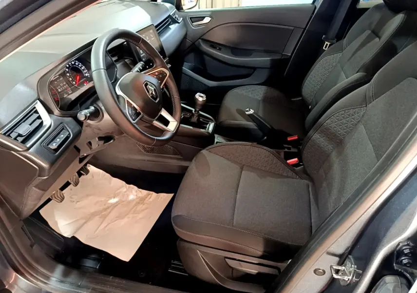 Intérieur de la Renault Clio Business TCe 90 2022 en gris foncé, vue côté conducteur montrant tableau de bord et sièges tissu.