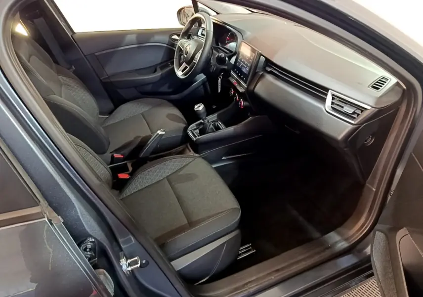 Vue intérieure côté conducteur de la Renault Clio Business TCe 90 2022, sièges tissu gris foncé et tableau de bord moderne.