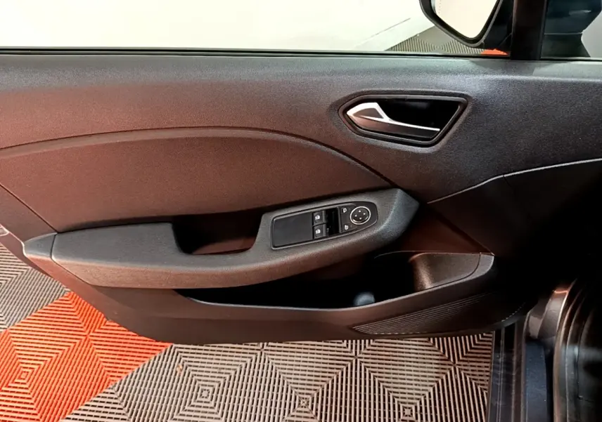 Gros plan sur la porte côté conducteur gris foncé de la Renault Clio Business TCe 90 avec commandes électriques des vitres.
