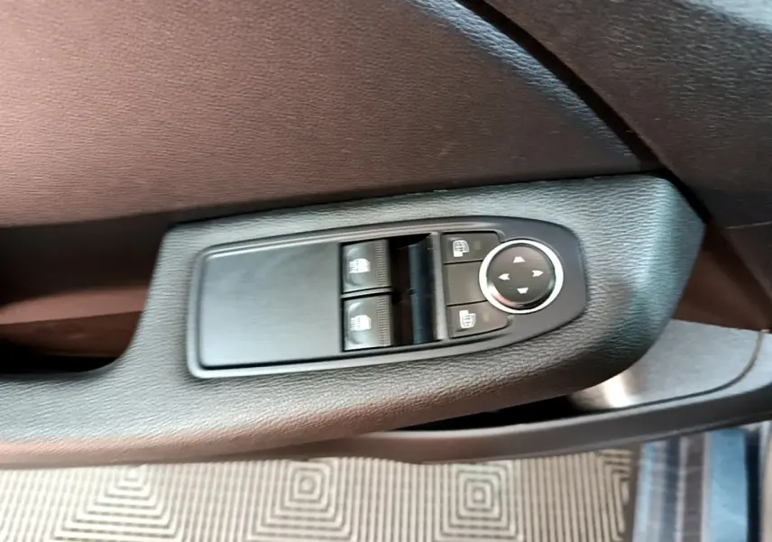 Gros plan sur les commandes de réglage des rétroviseurs chauffants côté conducteur d'une Renault Clio Business gris foncé 2022.