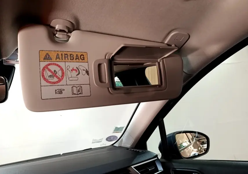 Miroir de courtoisie ouvert sur pare-soleil côté conducteur dans l'habitacle gris foncé d'une Renault Clio Business TCe 90 2022.