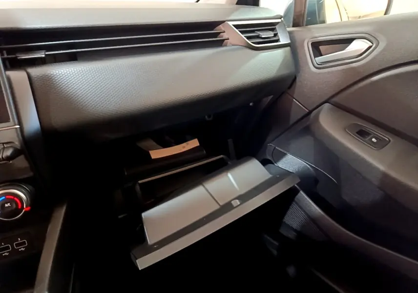 Intérieur de la Renault Clio Business TCe 90 2022, vue côté passager sur la boîte à gants ouverte et tableau de bord gris foncé.