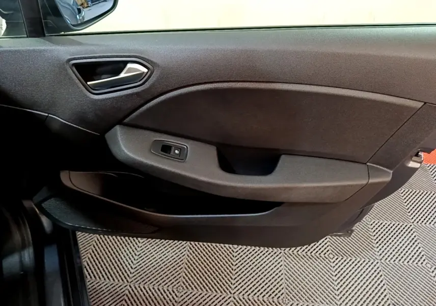 Vue rapprochée de la porte côté conducteur de la Renault Clio Business TCe 90 2022 en gris foncé, avec poignée et commande de vitre.
